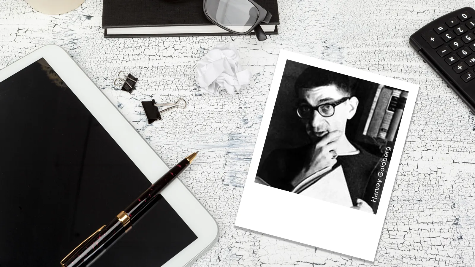 photo of Harvey goldberg on table with ipad, book, pen, glasses, clips